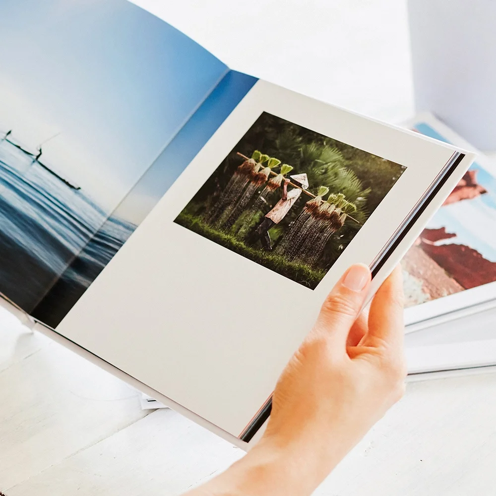 Hands holding an open hardcover photo book